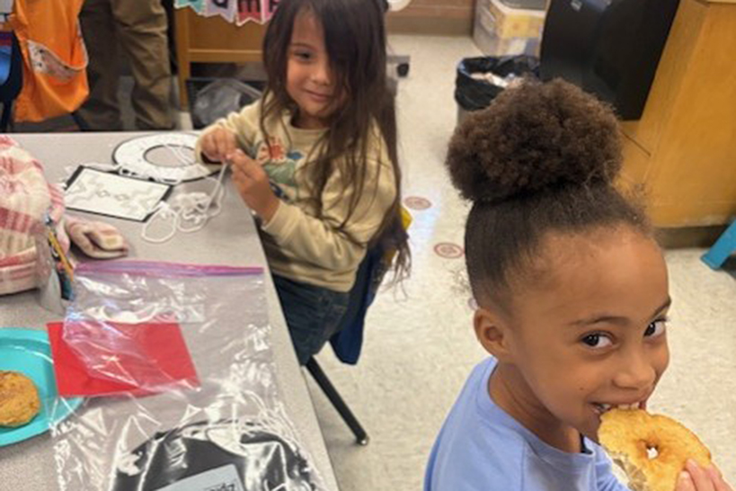 A girl bites into a piece of frybread