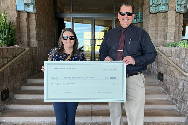 A woman and man hold up a giant check